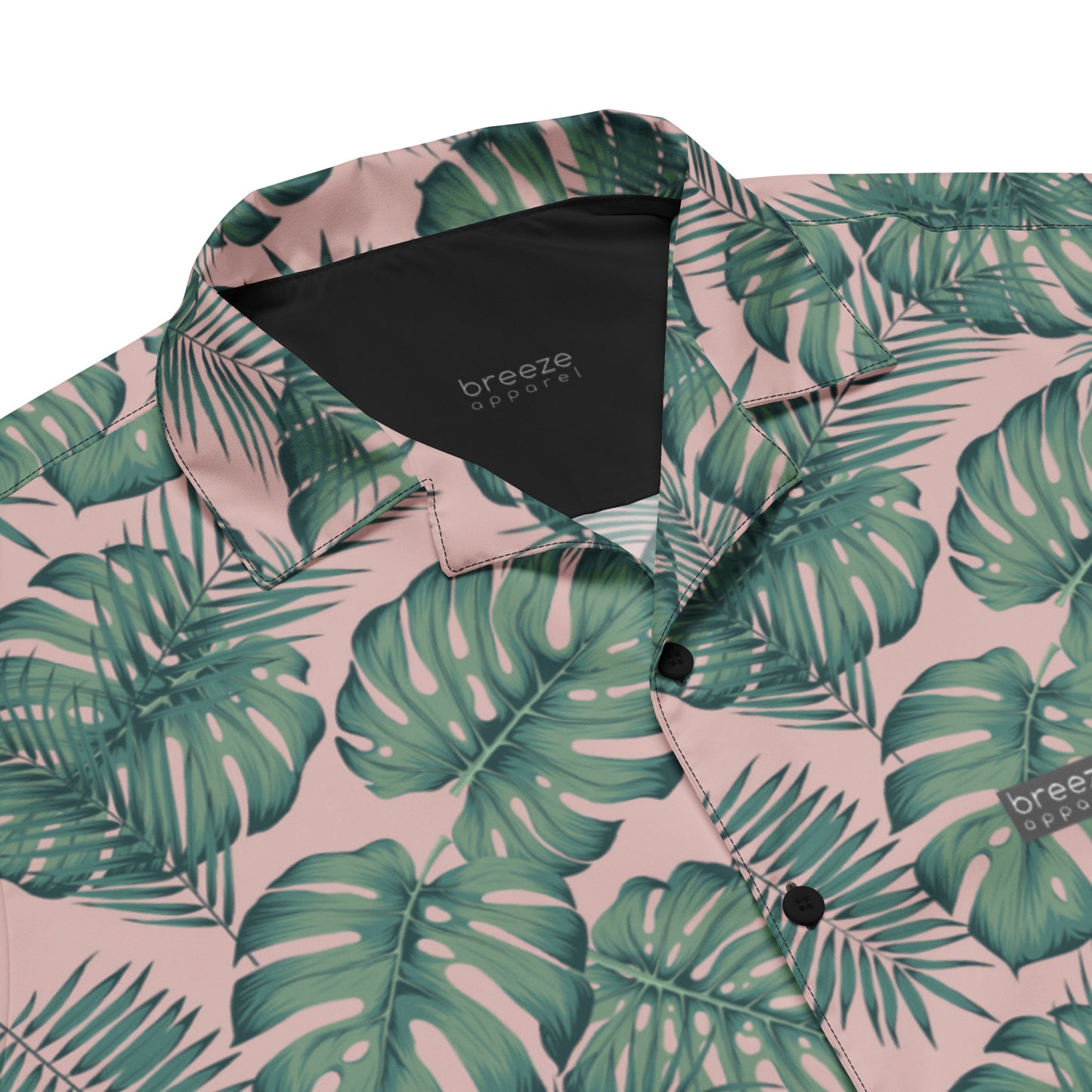 Button-down shirt with pattern of green palm leaves set on a pink background.