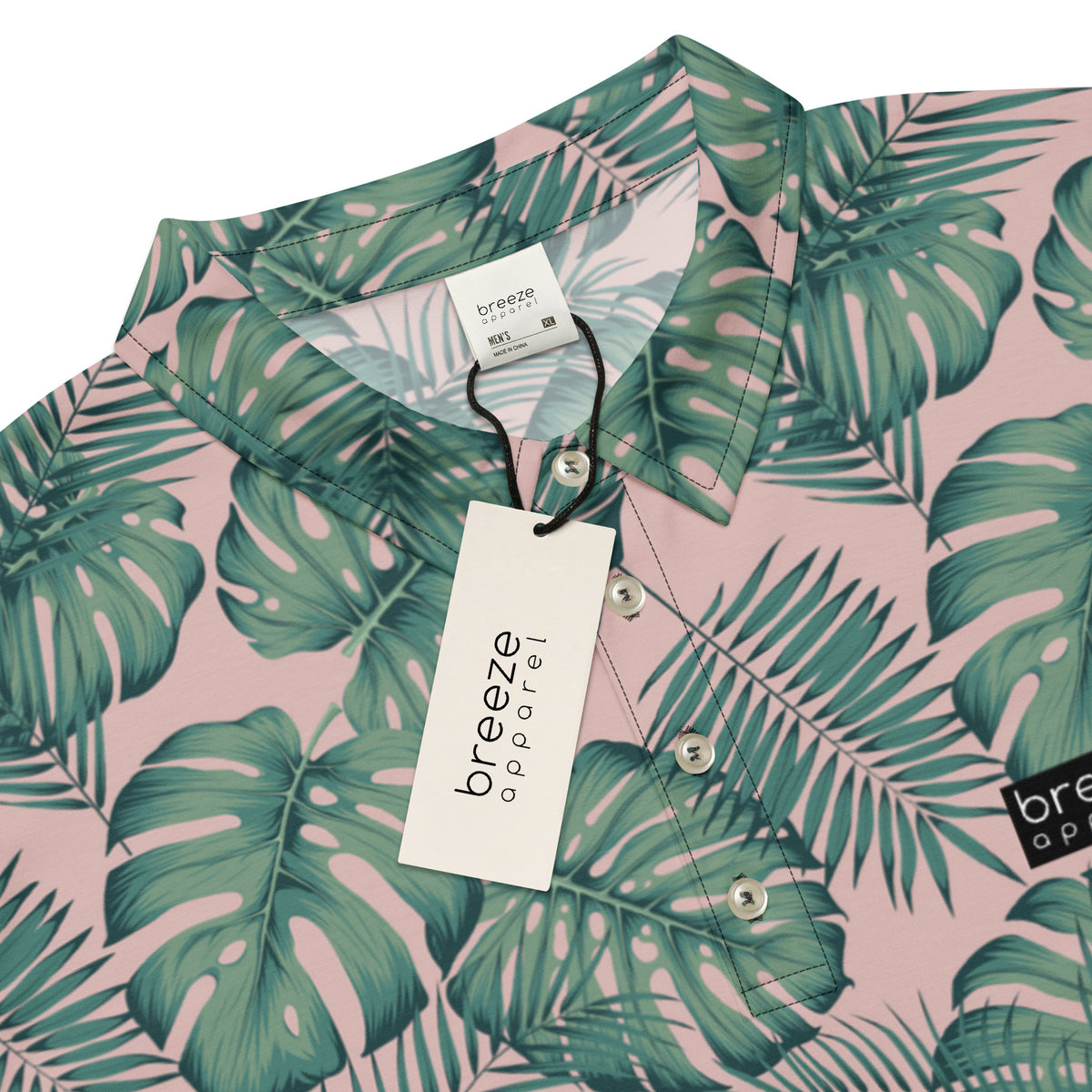 Polo with pattern of green palm leaves set on a light-pink background.