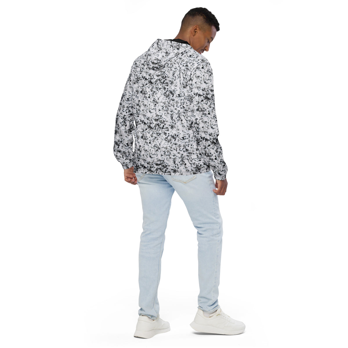 Rear view of man wearing jacket with pattern of black splotches on a white background.