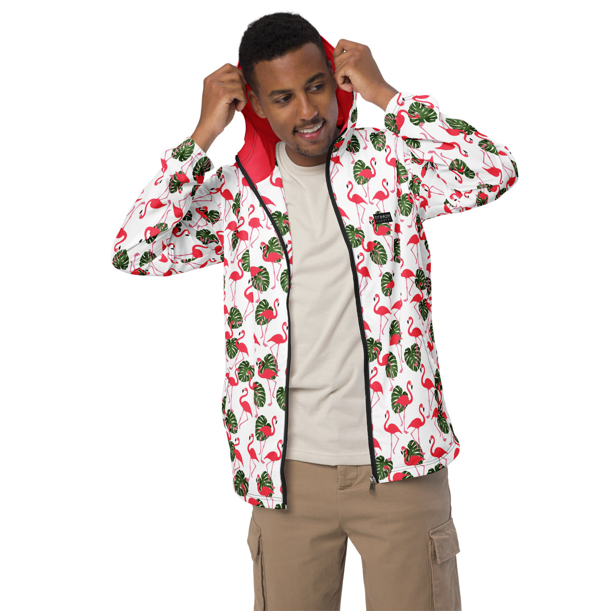 Man wearing jacket with pattern of pink flamingos and green foliage set on a white background.