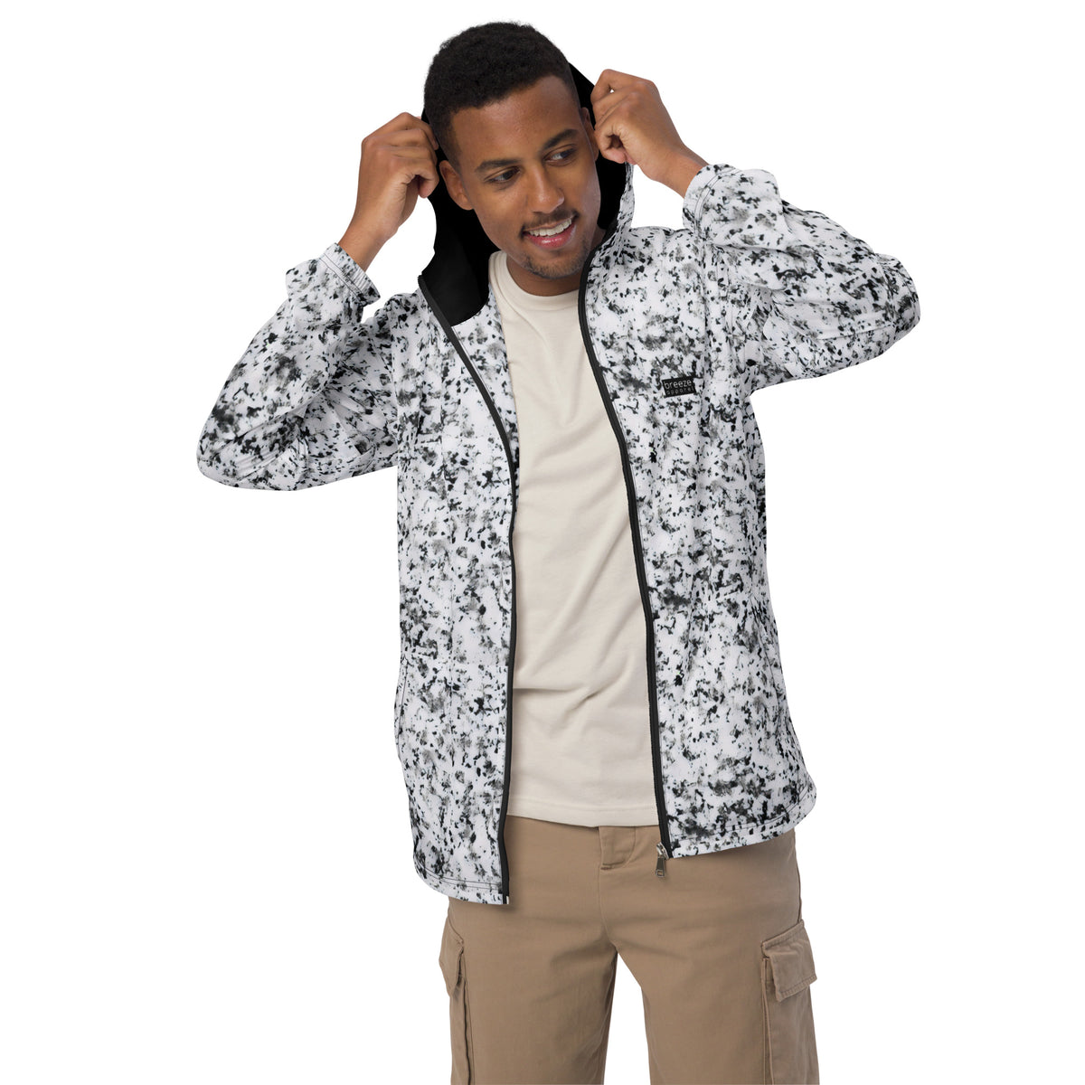 Man wearing jacket with pattern of black splotches on a white background.