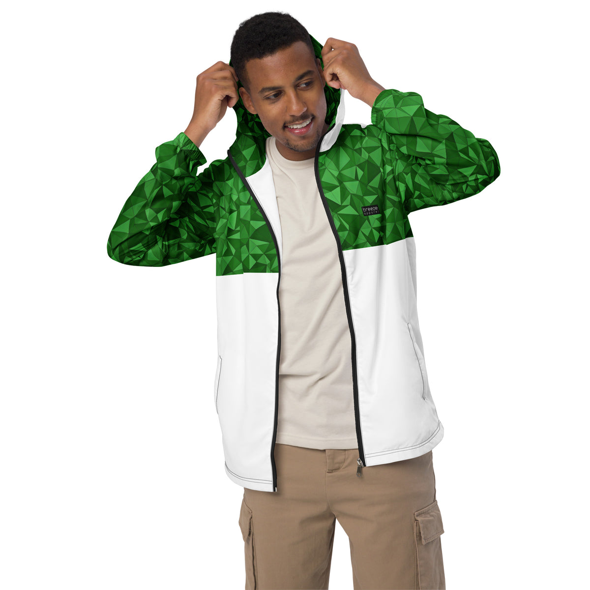 Man wearing windbreaker with green geometric pattern on top half, hood interior, and sleeves; rest is white.