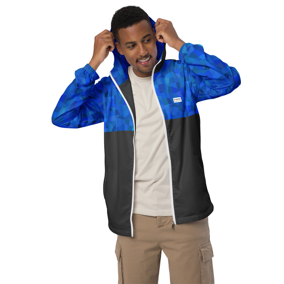 Man wearing jacket with blue geometric pattern on top, hood interior, and sleeves; rest is gray.