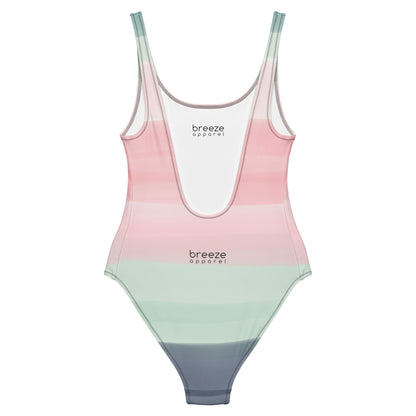 Back of one-piece swimsuit with a pink, pastel-green, and gray design that resembles watercolor.
