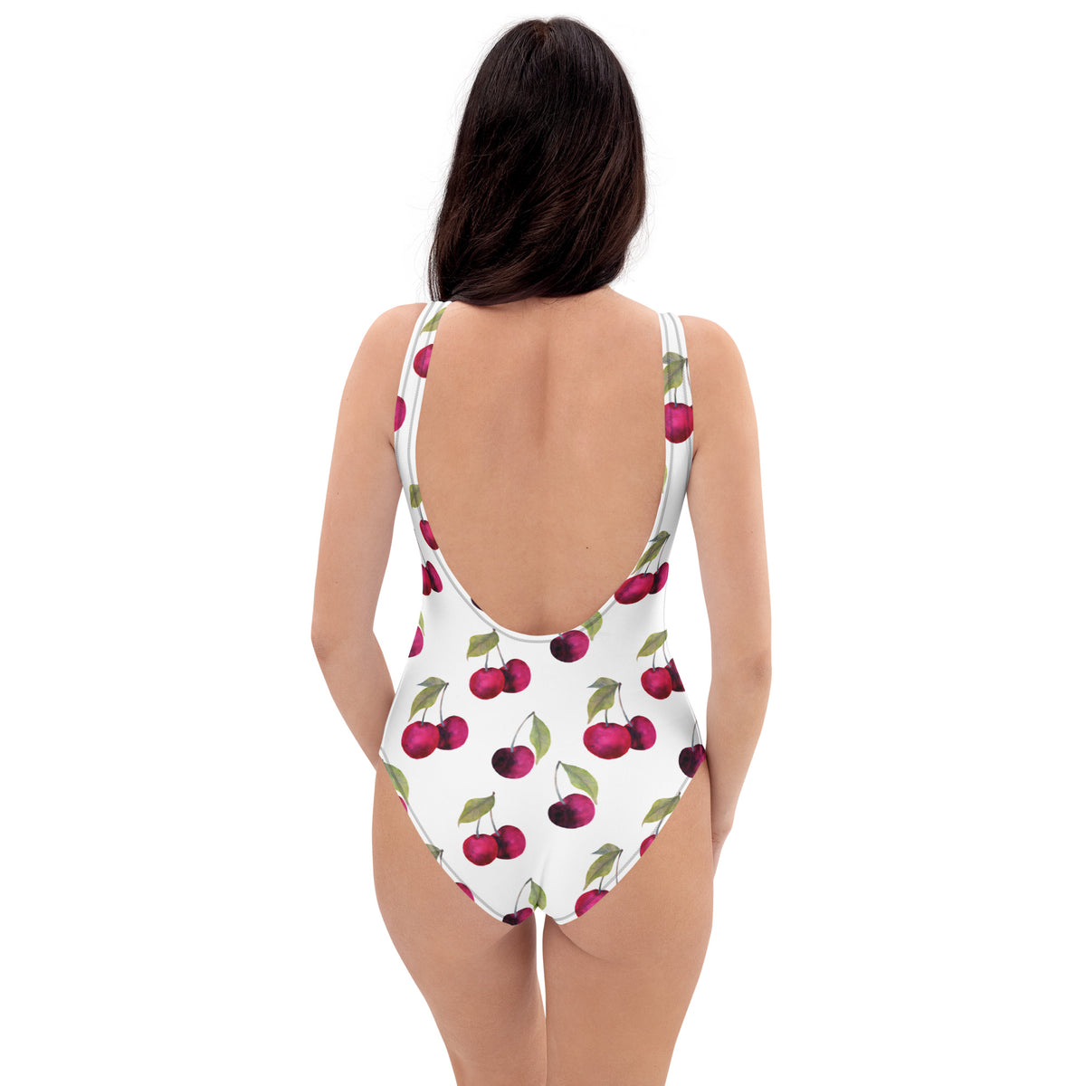 Woman wearing white, one-piece swimsuit with pattern of cherries.