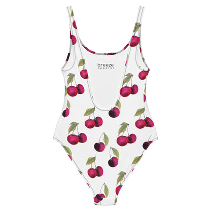White, one-piece swimsuit with pattern of cherries.