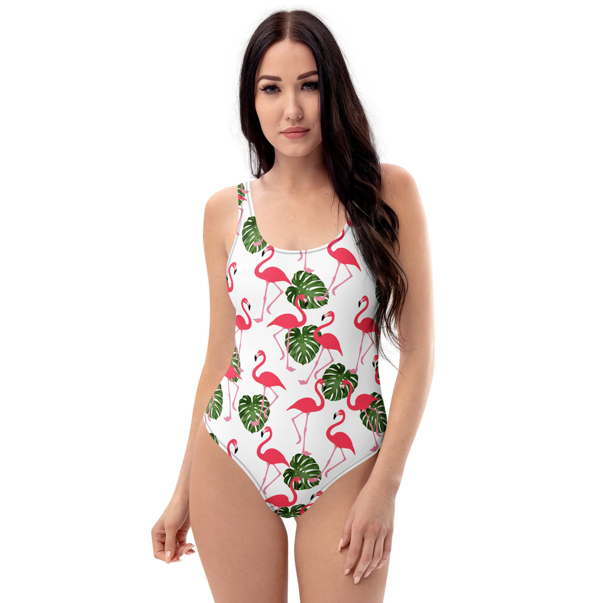 Woman wearing a white, one-piece swimsuit with a pattern consisting of flamingos and palm leaves. 