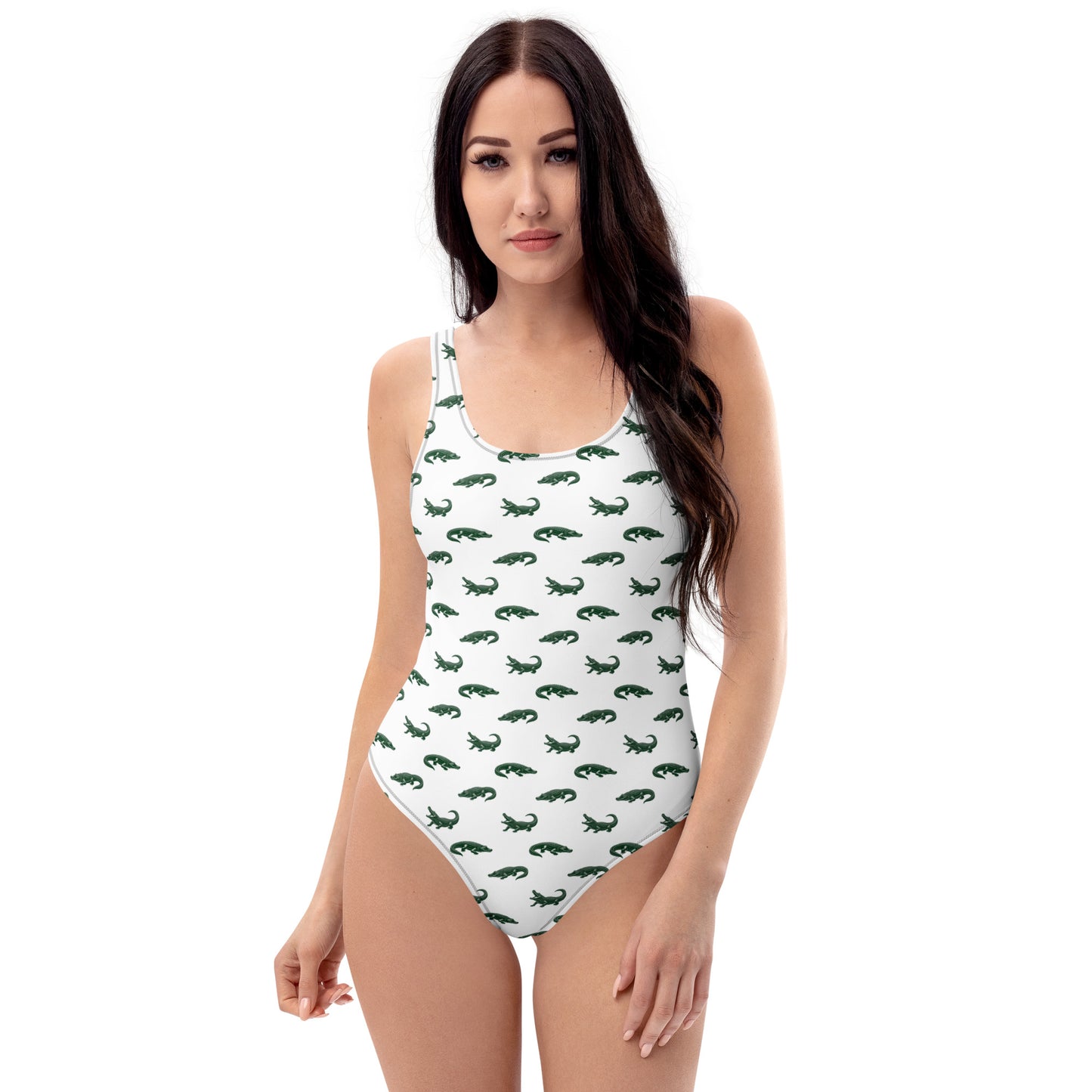 Woman wearing white one-piece swimsuit with pattern of green alligators.