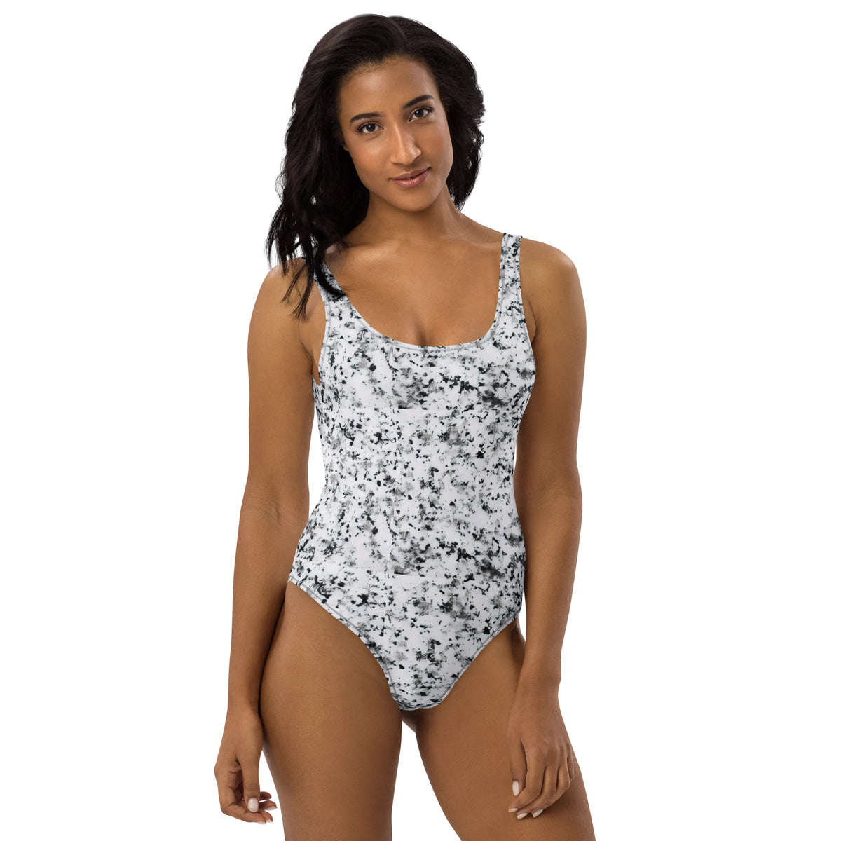 Woman wearing one-piece swimsuit with pattern of black splotches set on a white background.
