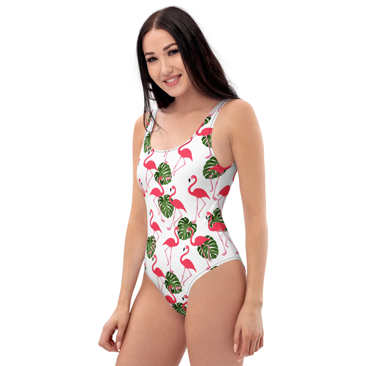 Woman wearing a white, one-piece swimsuit with a pattern consisting of flamingos and palm leaves. 