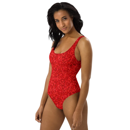 Woman wearing one-piece swimsuit with an all-over, red geometric pattern.