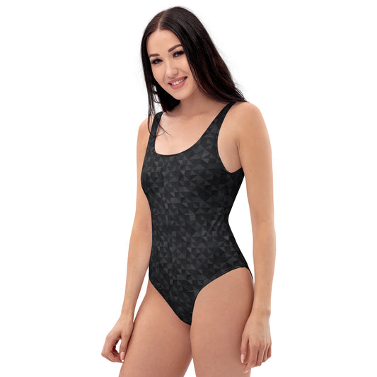 Woman wearing one-piece swimsuit with black geometric pattern.
