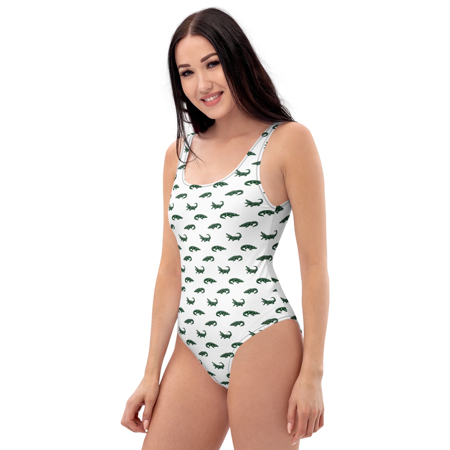 Woman wearing white one-piece swimsuit with pattern of green alligators.