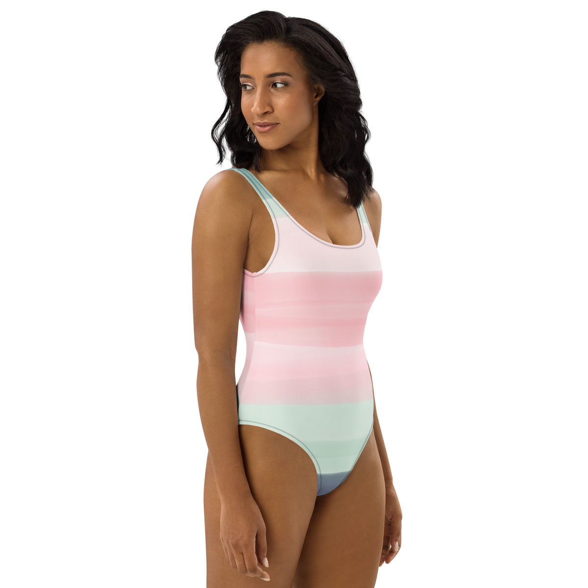 Woman wearing a one-piece swimsuit with a pink, pastel-green, and gray design that resembles watercolor.