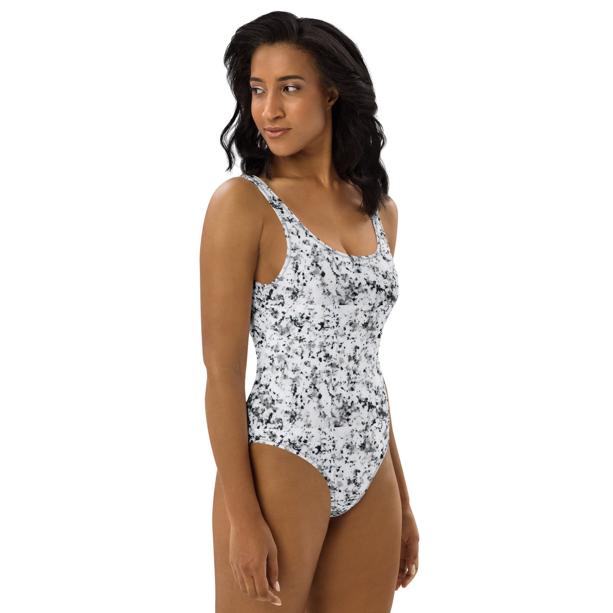 Woman wearing one-piece swimsuit with pattern of black splotches set on a white background.