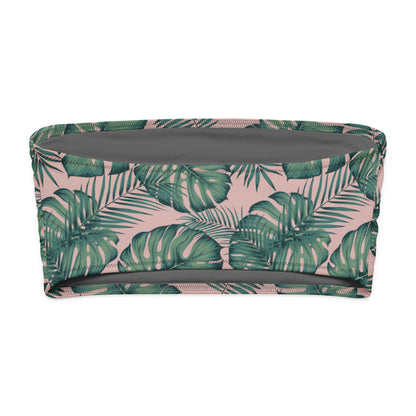 Back of bandeau bikini top with design of green palm leaves set on a pink background.