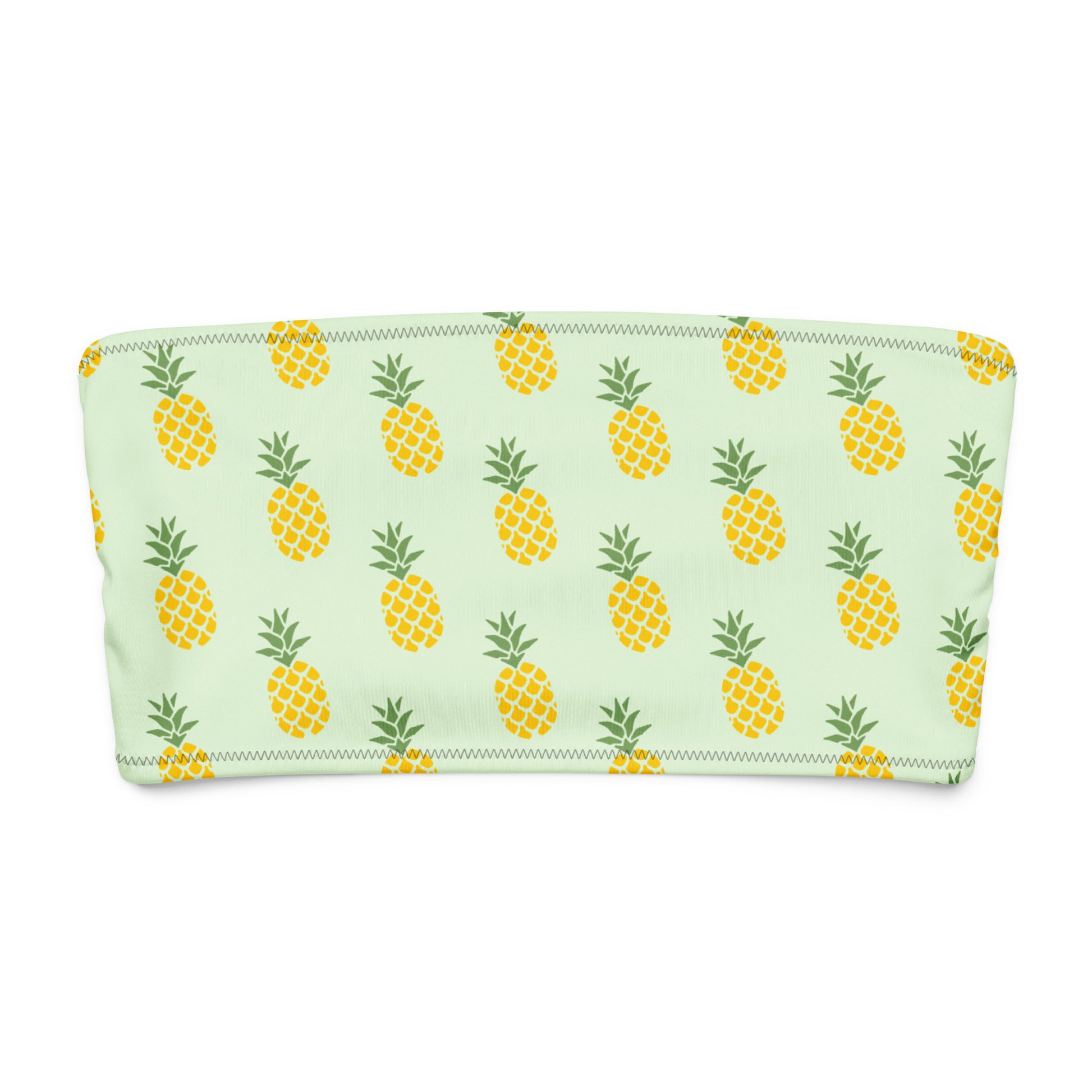 Bandeau bikini top with all-over pineapple design, set on a light-green background.