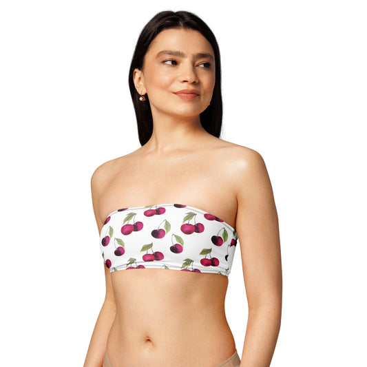 Woman wearing white bandeau bikini top with all-over cherries design.