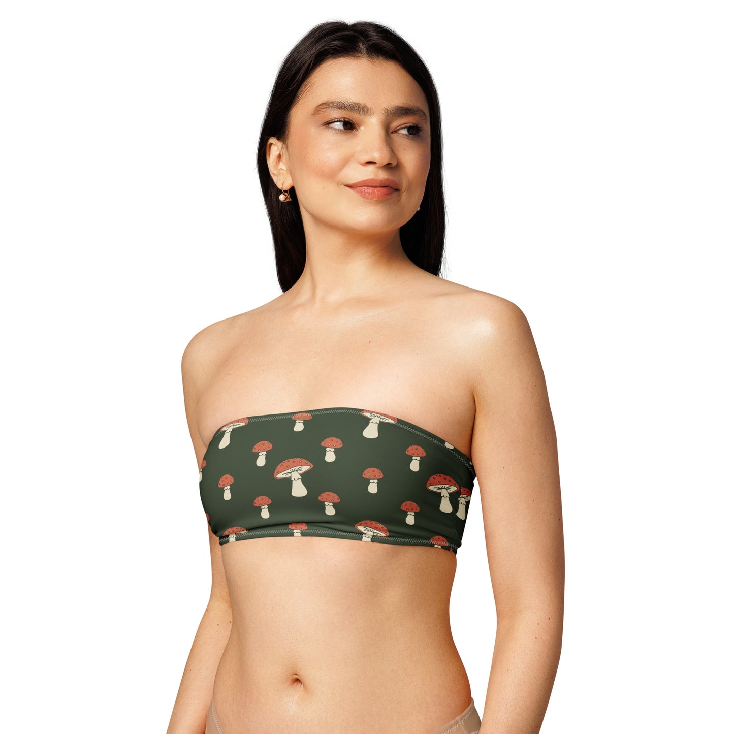 Woman wearing bandeau bikini top with all-over design of mushrooms set on a dark-green background.