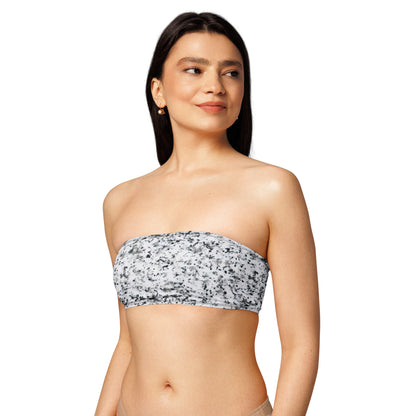 Woman wearing bandeau bikini top that has a pattern of black splotches set on a white background.