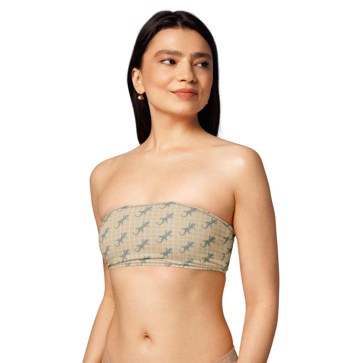 Woman wearing beige bikini top with pattern of green geckos.
