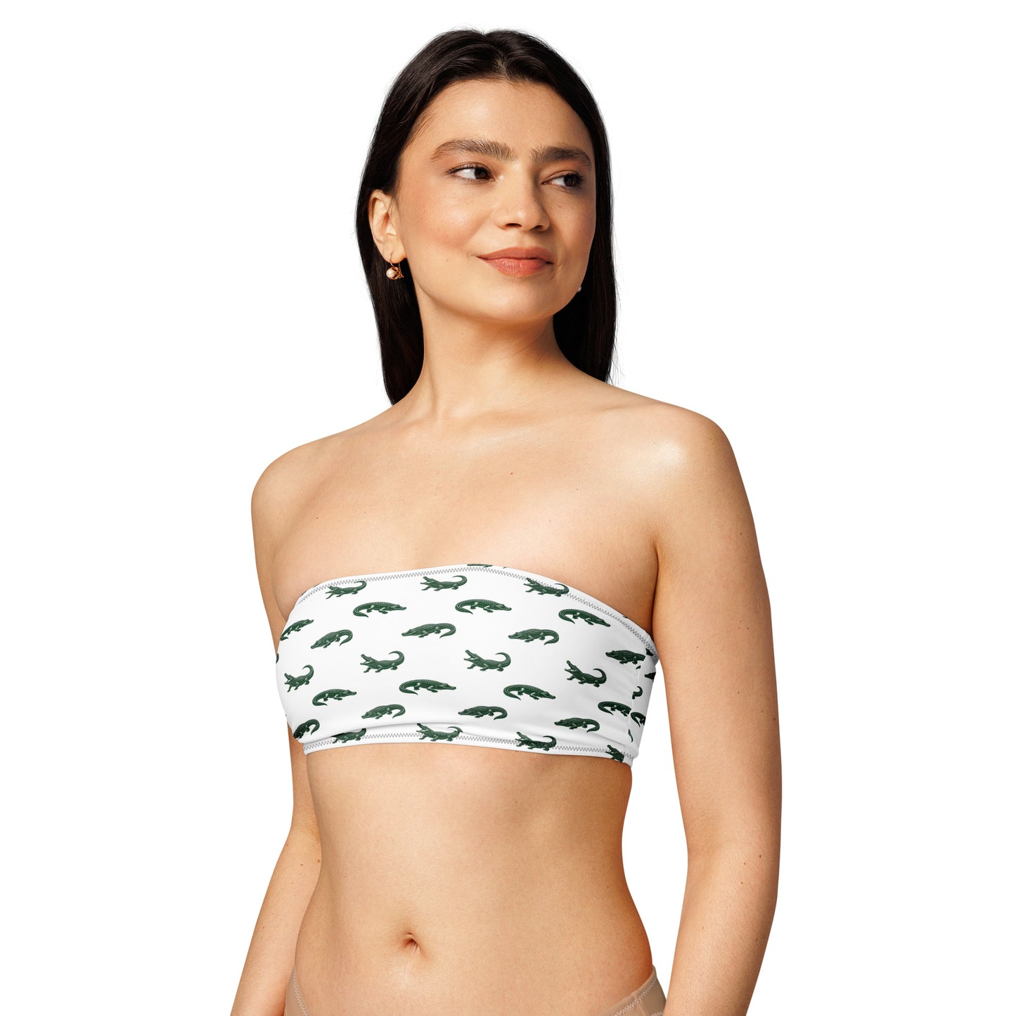 Woman wearing white bikini top with pattern of green alligators.
