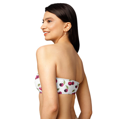 Rear view of woman wearing white bandeau bikini top with all-over cherries design.