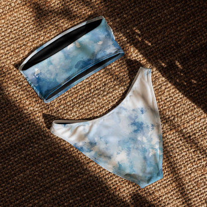 Back of bandeau bikini with a blue-white, watercolor-like design, laying in sunlight.