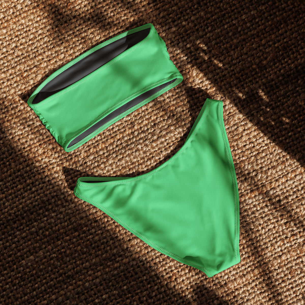Back of mint-green bandeau bikini laying in sunlight.
