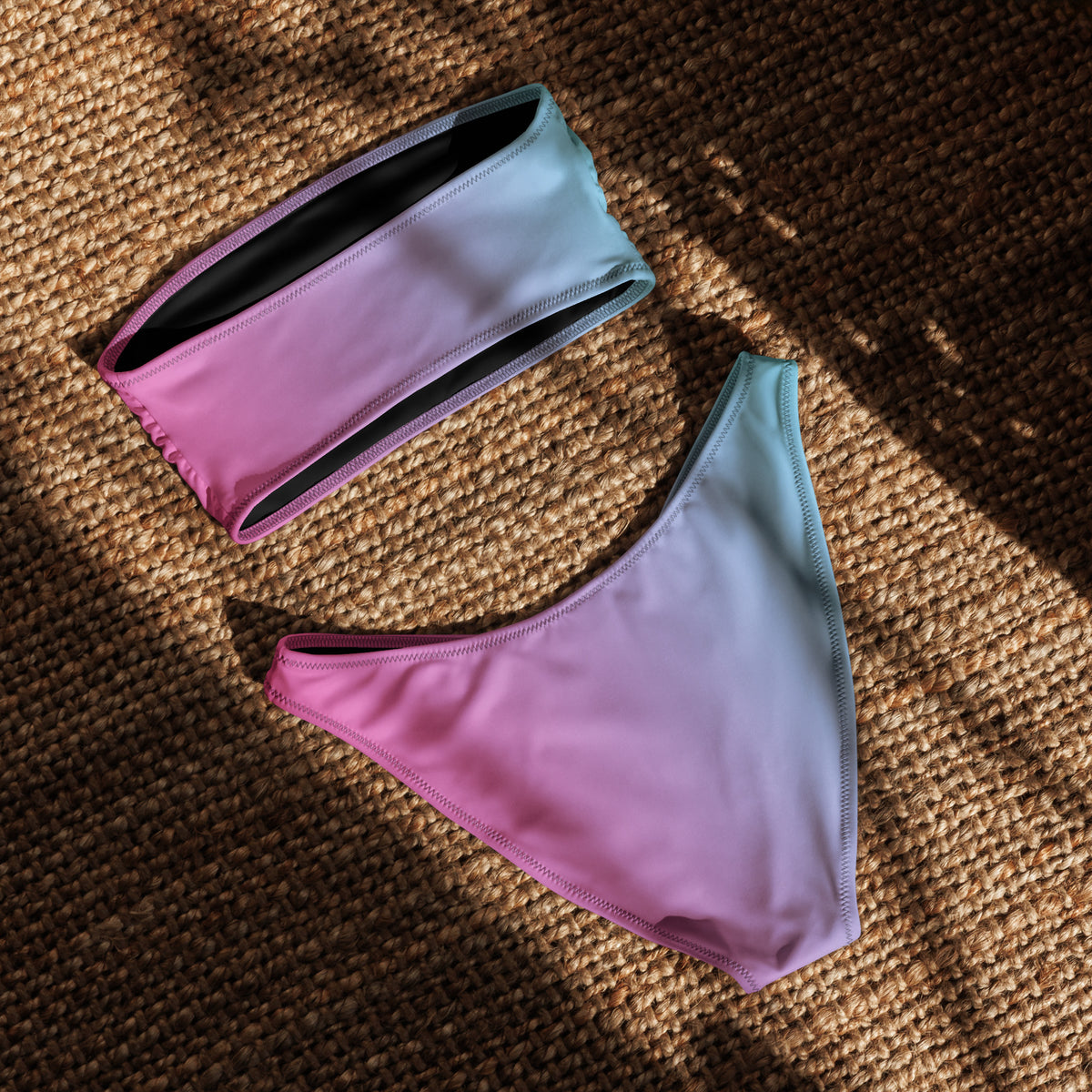 Back of bandeau bikini with a pink-to-blue color pattern, laying in sunlight.