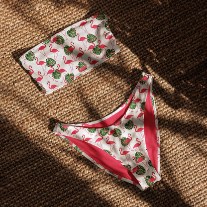 White bandeau bikini with all-over flamingos design, laying in sunlight.