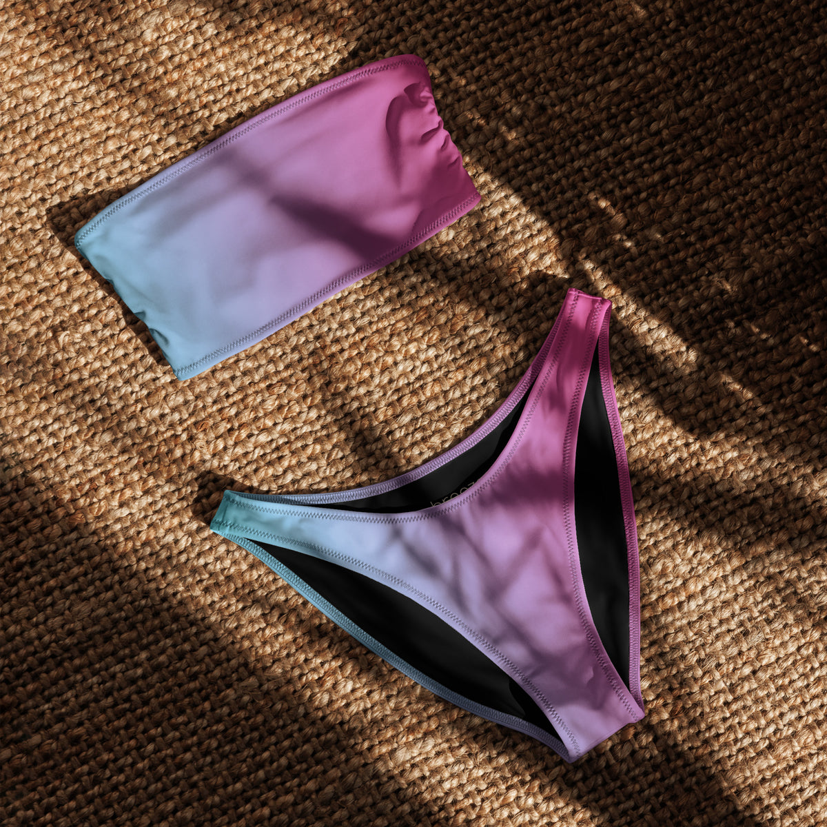 Bandeau bikini with a blue-to-pink color pattern, laying in sunlight.
