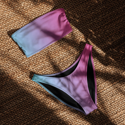Bandeau bikini with a blue-to-pink color pattern, laying in sunlight.