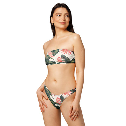 Woman wearing bandeau bikini with tropical floral pattern.
