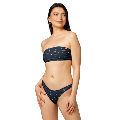 Woman wearing bikini with pattern of UFOs and planets in space.