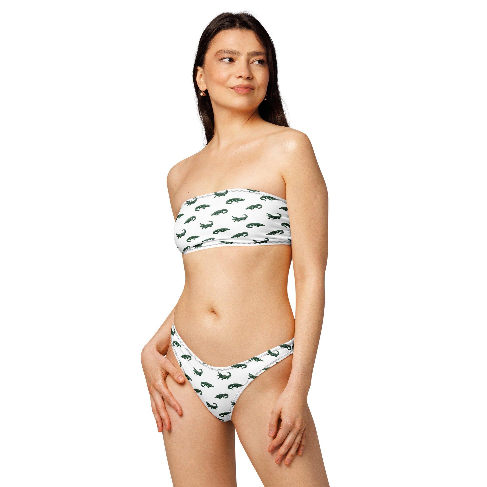 Woman wearing white bikini with pattern of green alligators.