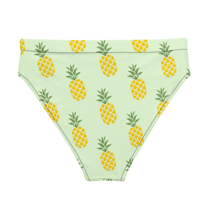 Back of bikini bottom with pineapple pattern set on a light-green background.