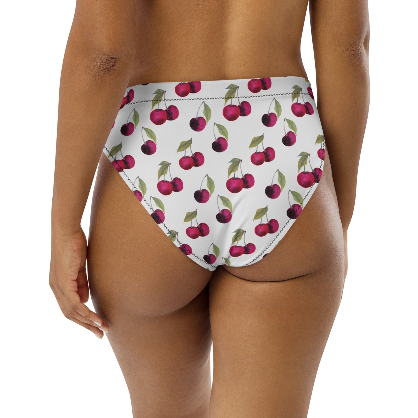 Rear view of woman wearing bikini bottom with all-over cherry pattern set on white background.