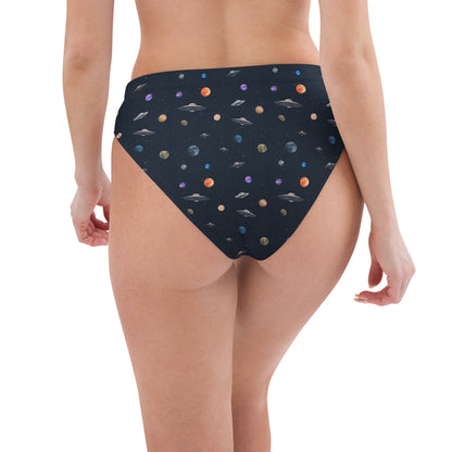 Woman wearing bikini bottom with pattern of UFOs and planets in space.