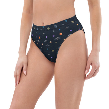 Woman wearing bikini bottom with pattern of UFOs and planets in space.