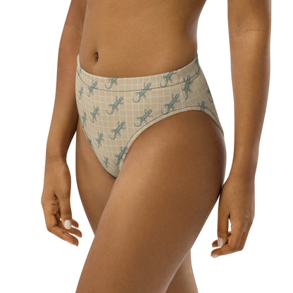 Woman wearing beige bikini bottom with pattern of green geckos.