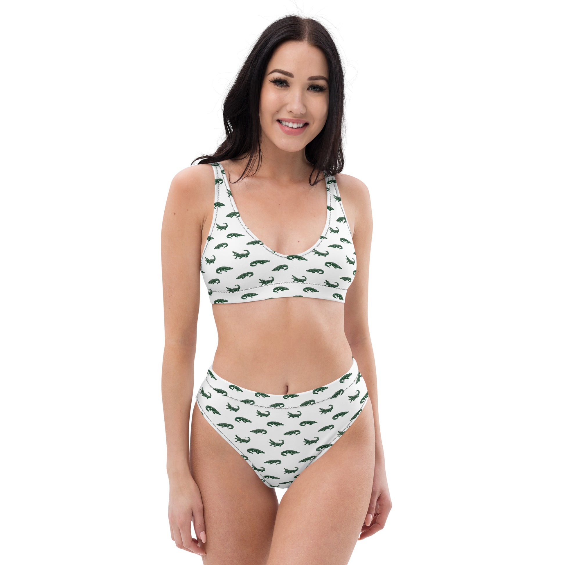 Woman wearing white bikini with pattern of green alligators. 