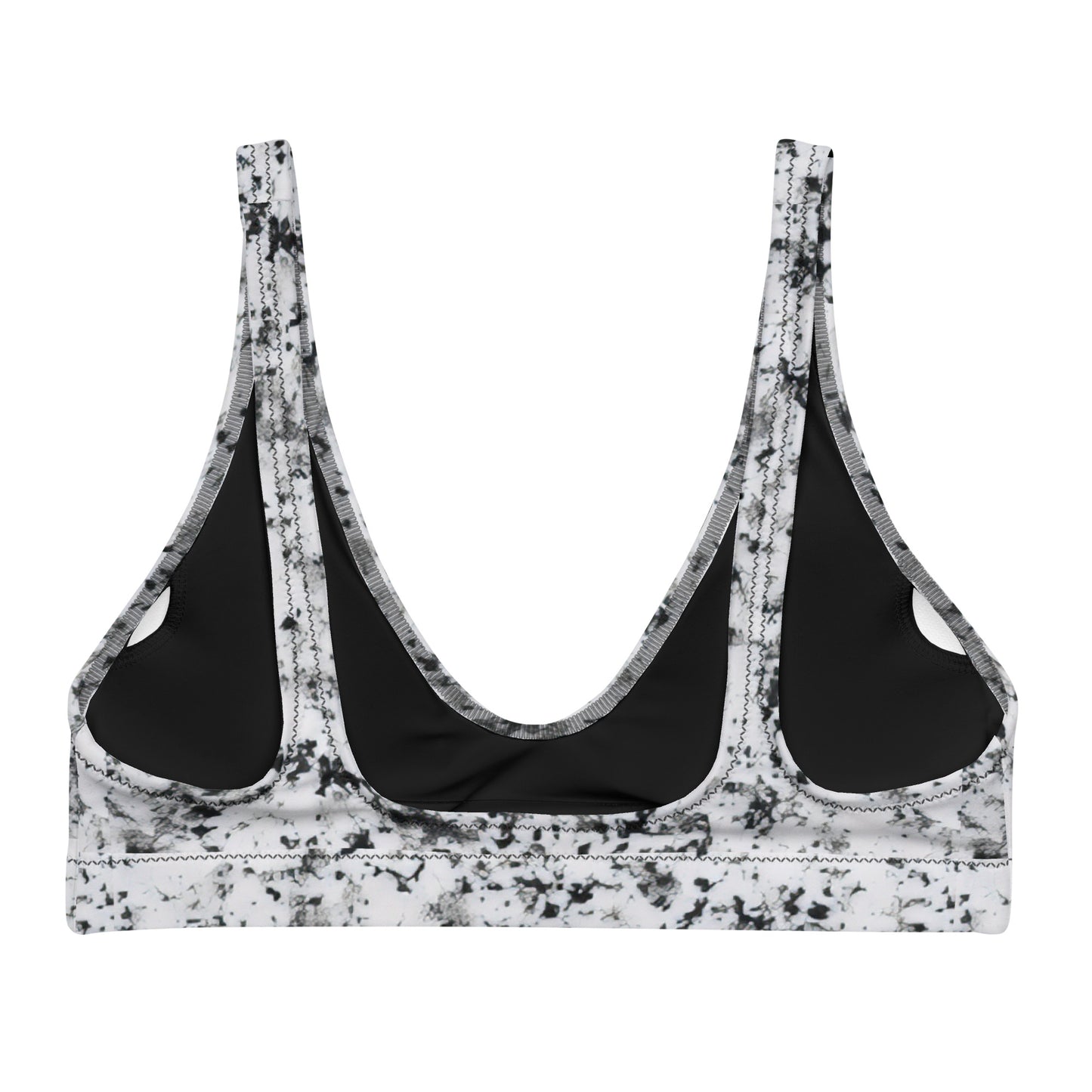 Back of bikini top with pattern of black splotches set on a white background.