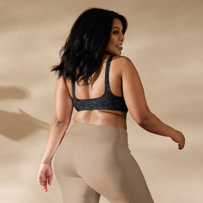 Rear view of woman wearing bikini top with dark-gray geometric pattern.
