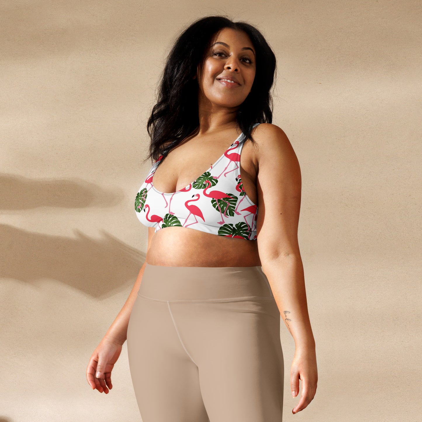 Woman wearing bikini top with all-over flamingo pattern set on white background.