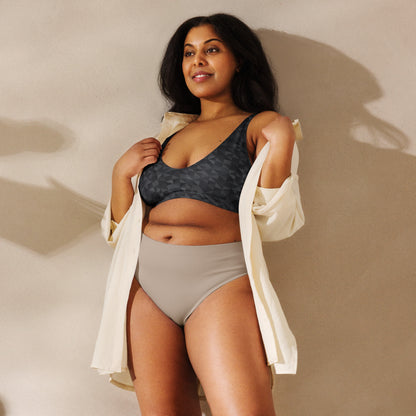 Woman wearing bikini top with dark-gray geometric pattern.