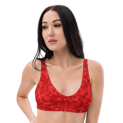 Woman wearing bikini top with red geometric pattern.