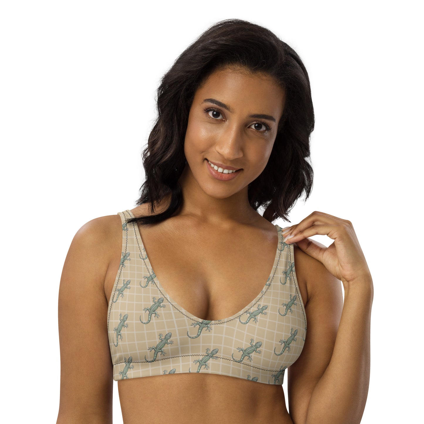 Woman wearing beige bikini top with pattern of green geckos.