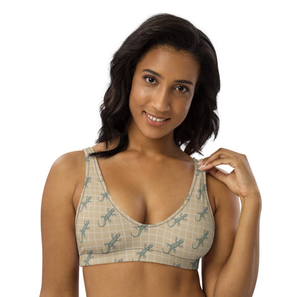 Woman wearing beige bikini top with pattern of green geckos.