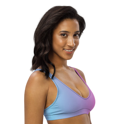 Woman wearing bikini top with blue-to-pink color scheme.